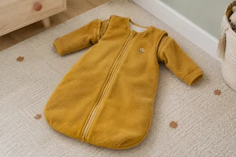Gigoteuse bébé en polaire moutarde à manches amovibles, avec zip intégral et broderie sur la poitrine.